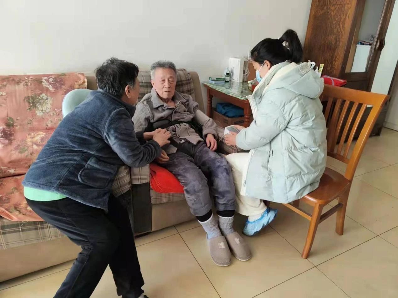 照护管理师为签约家庭养老照护床位老年人进行健康管理。