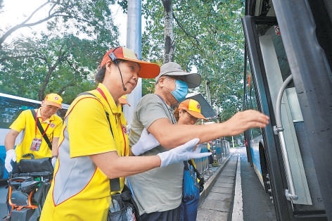 文明引导员搀扶老人上车。（摄影：程功）